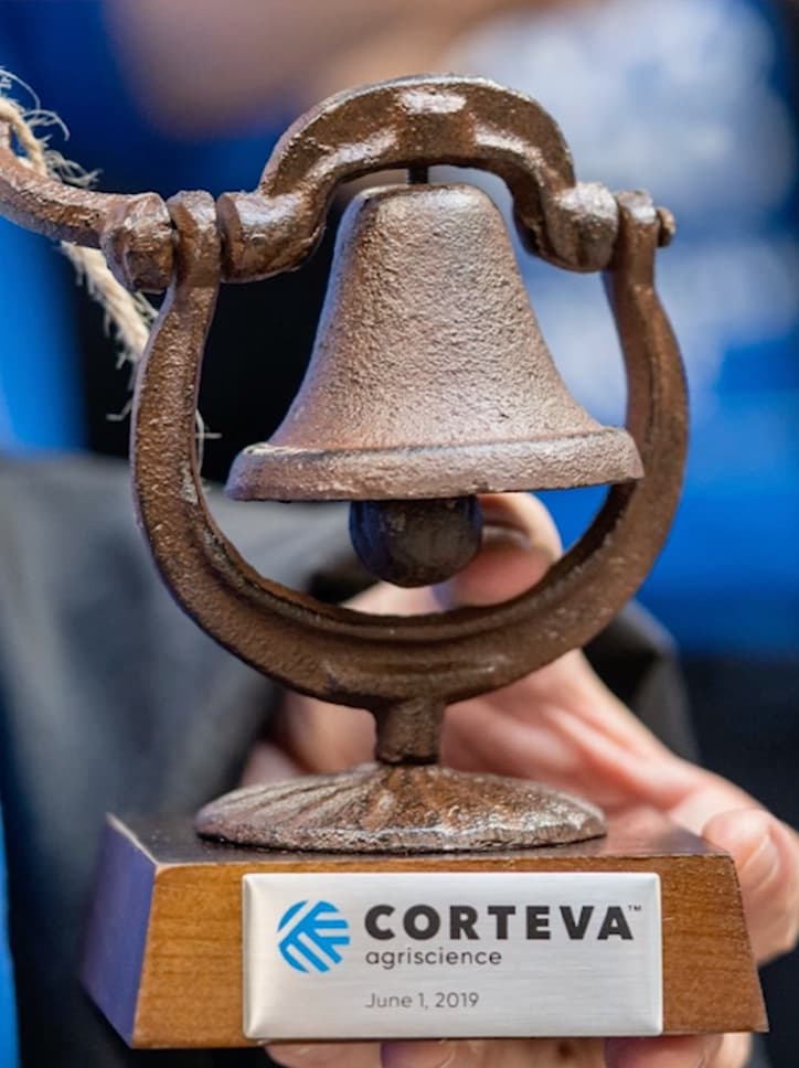Troféu de um evento corporativo da Corteva Agriscience, datado de 1º de junho de 2019. O prêmio é um sino de metal sobre uma base de madeira.