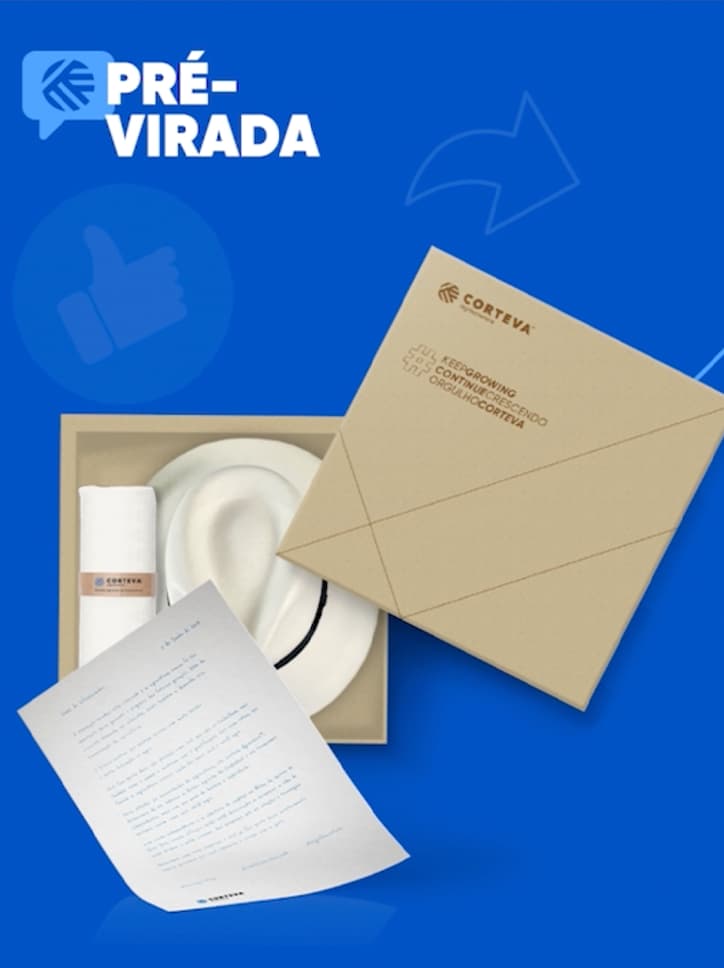 Foto de unboxing de um brinde corporativo da Corteva, exibindo um chapéu, uma toalha e uma carta da campanha.